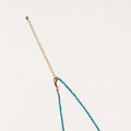 Dainty teal apatite beaded necklace with a single freshwater pearl centerpiece flanked by two small gold beads, adjustable gold clasp.