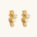 Pair of gold-plated double flower earrings with textured petals and crystal centers on cream background.