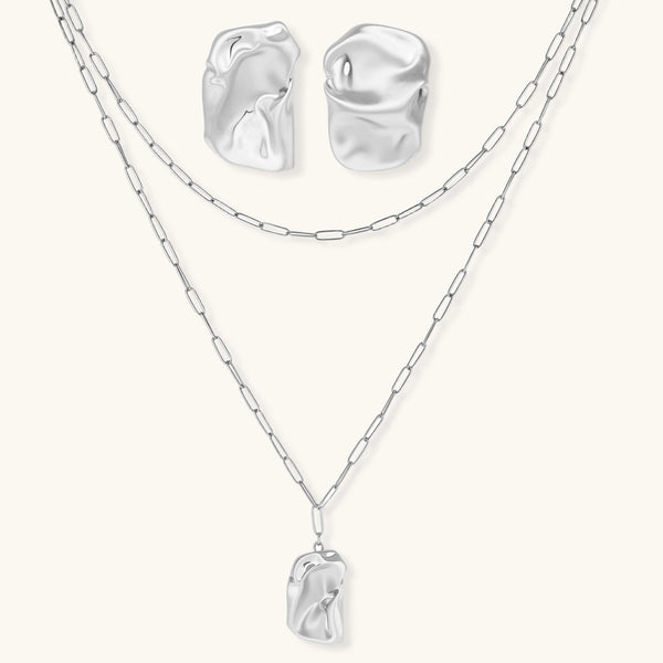 Modern textured hoop earrings and layered chain necklace with liquid metal pendant in silver and gold finishes.