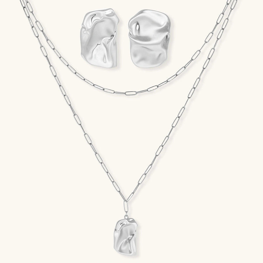 Modern textured hoop earrings and layered chain necklace with liquid metal pendant in silver and gold finishes.