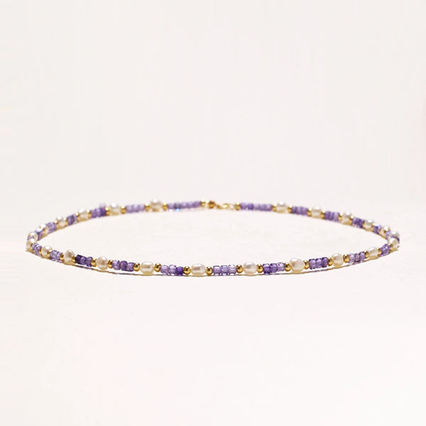 Delicate 18K gold vermeil necklace with alternating lavender zirconia beads and white freshwater pearls on cream background