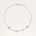 Delicate pearl necklace with pale green serpentine jade centerpiece and colorful agate beads on cream background