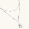 Modern textured hoop earrings and layered chain necklace with liquid metal pendant in silver and gold finishes.