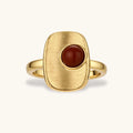 Close-up of brushed 18K gold-plated ring featuring red nanhong stone in geometric square setting with adjustable band