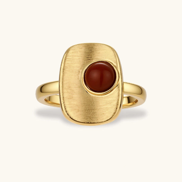 Close-up of brushed 18K gold-plated ring featuring red nanhong stone in geometric square setting with adjustable band